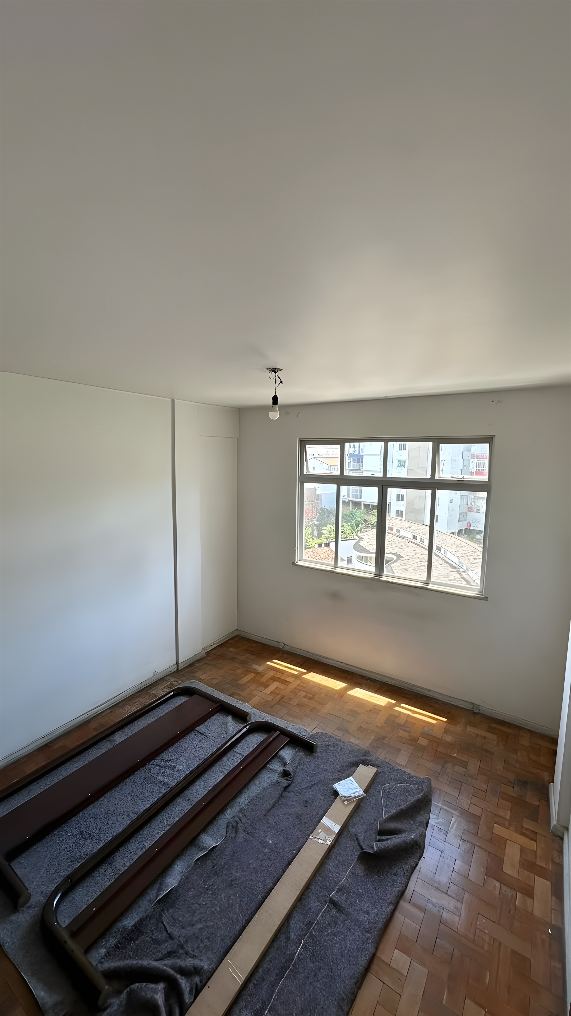 Segundo quarto vazio com piso em taco e janela