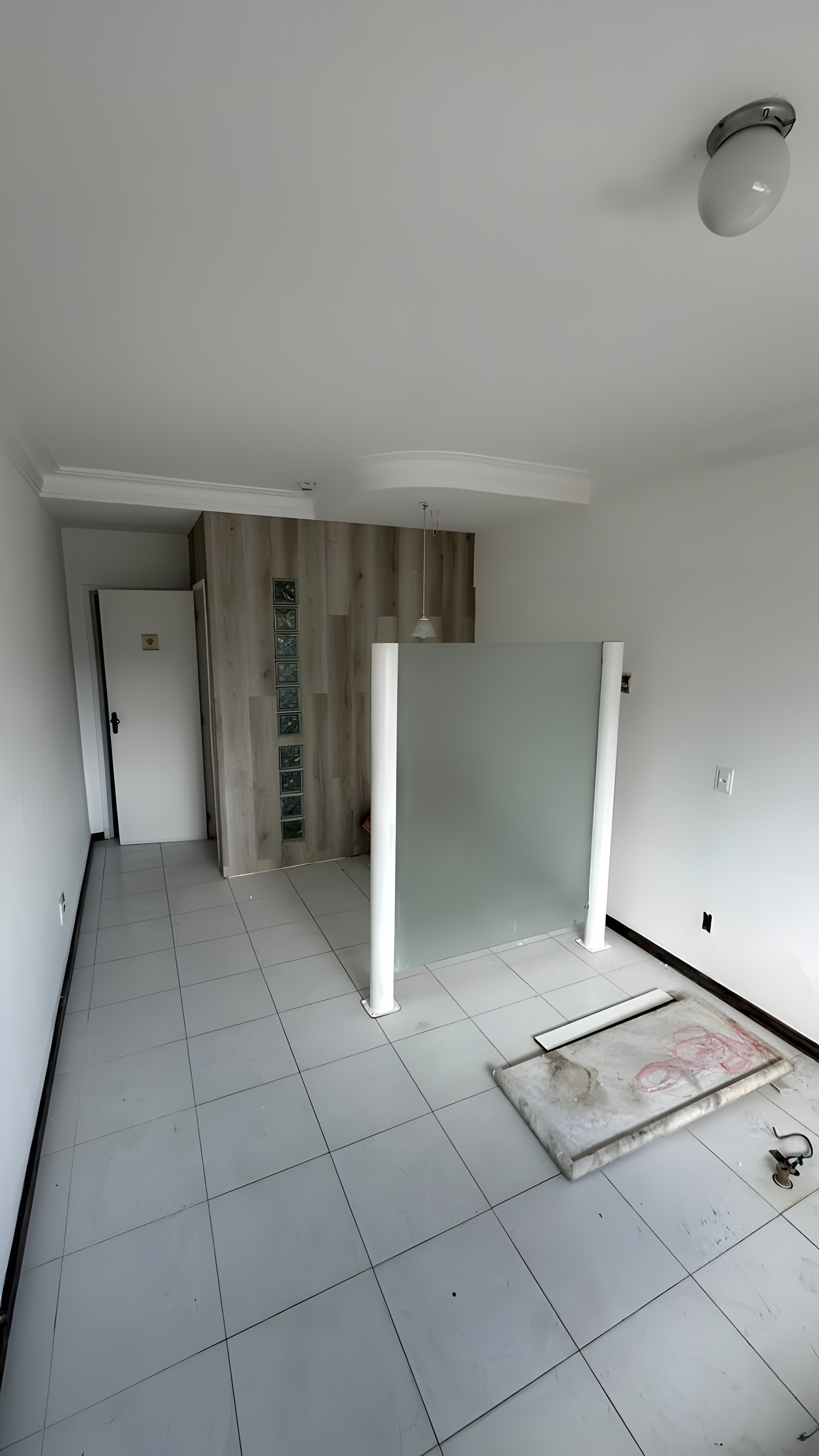 Sala existente com divisória em vidro e painel amadeirado ao fundo